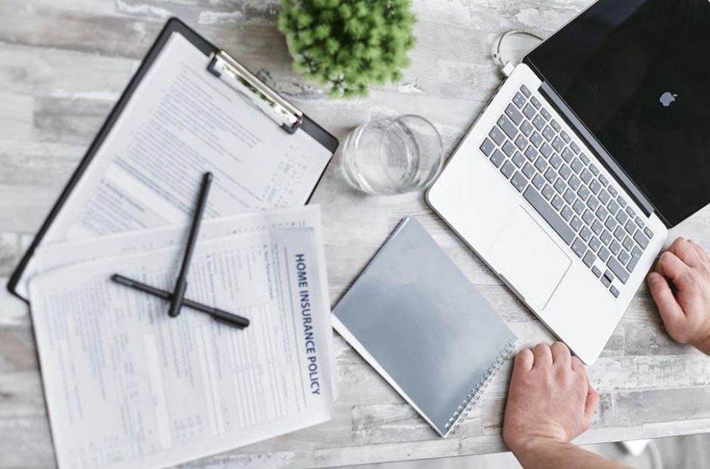Insurance paperwork and car keys on a desk during a policy signing