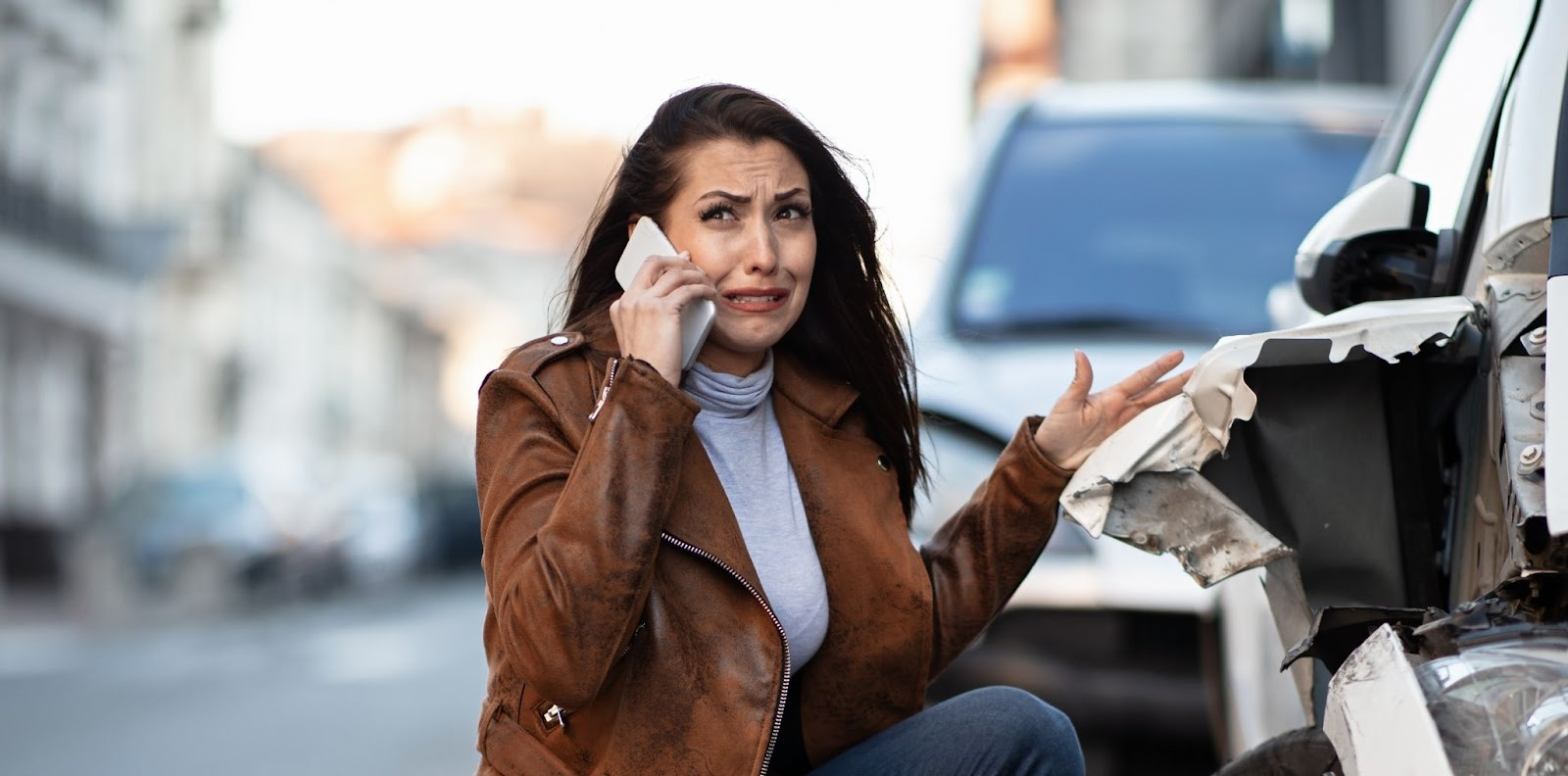 miserable woman crying while calling help mobile phone after car accident 1 e1694470938527