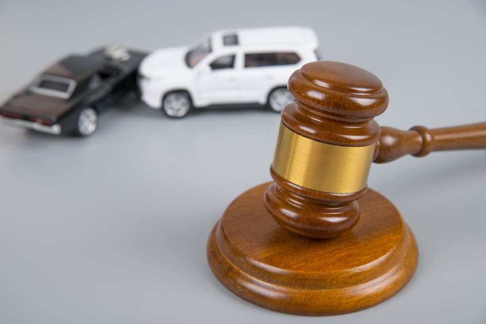 judges gavel with model car crash in background
